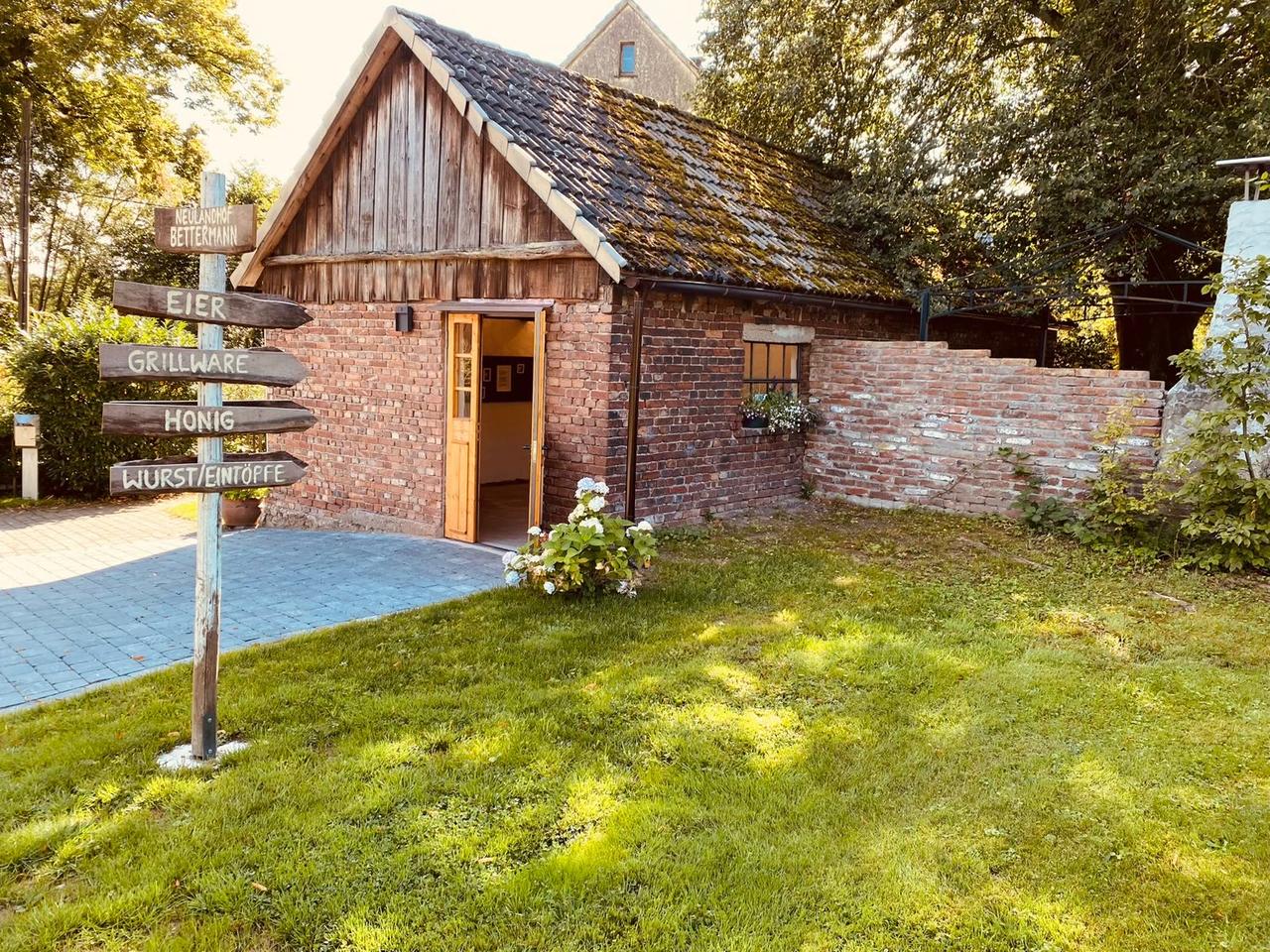 Neulandhof Bettermann · Wegweiser am Hof mit Eiern, Grillware, Honig und Wurst